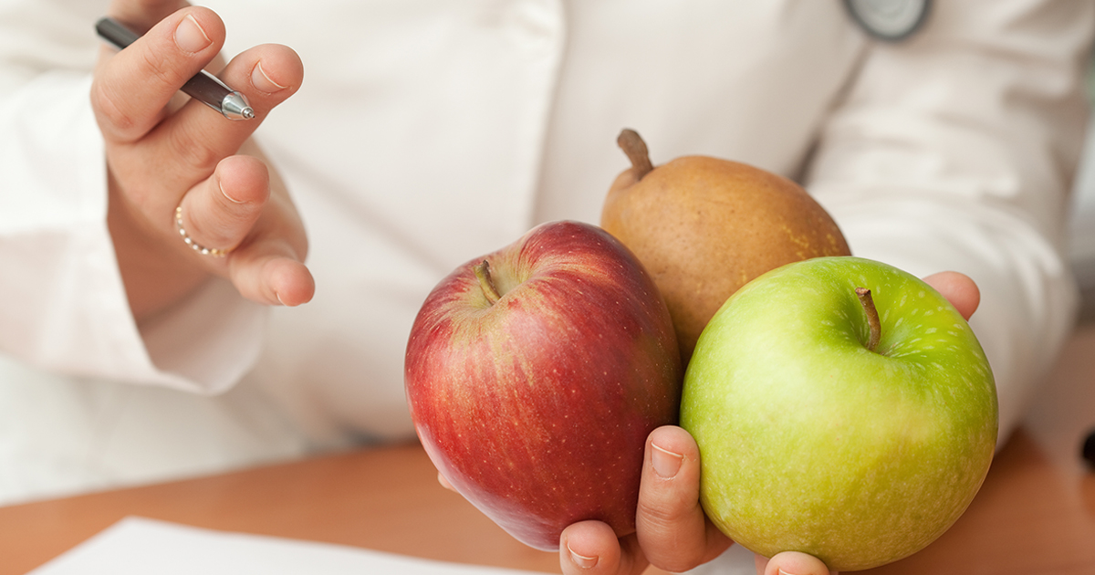 a physician holding healthy fruit