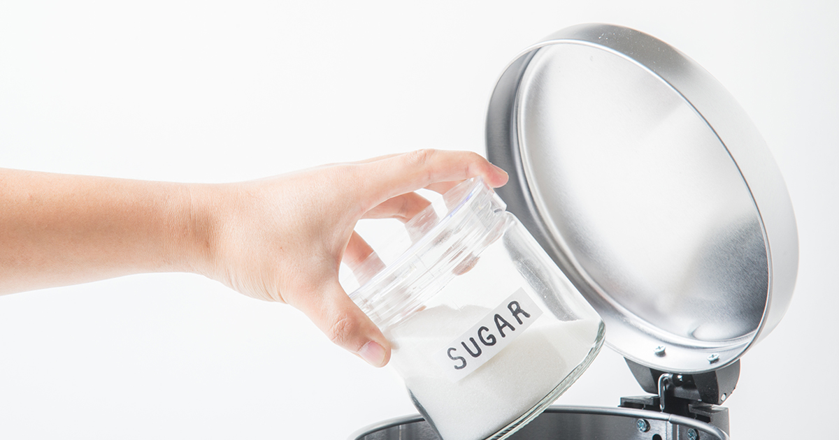 a jar of sugar being tossed in the trash