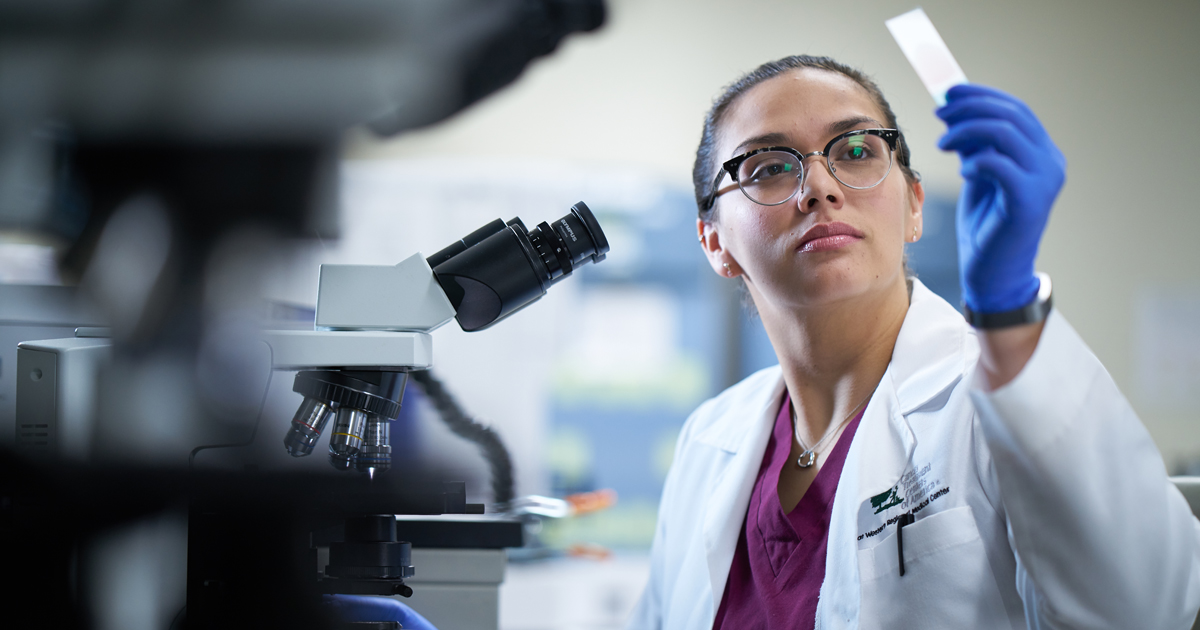 A female scientist reviewing a strip test in her hand