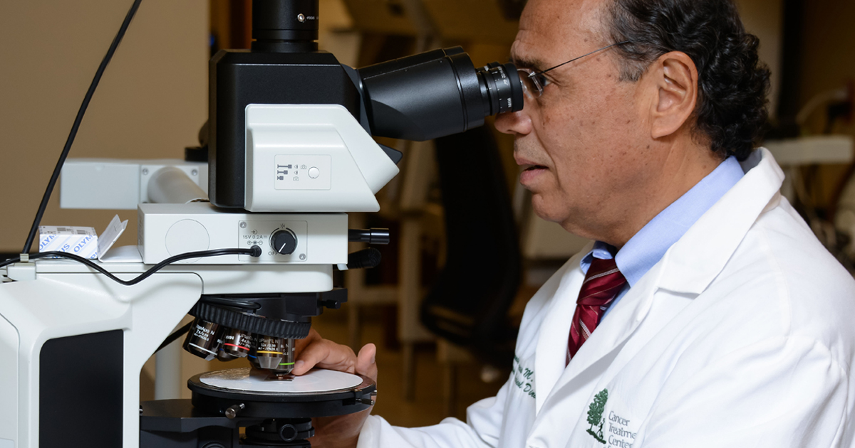Pathologist reviewing a specimen under the the microscope
