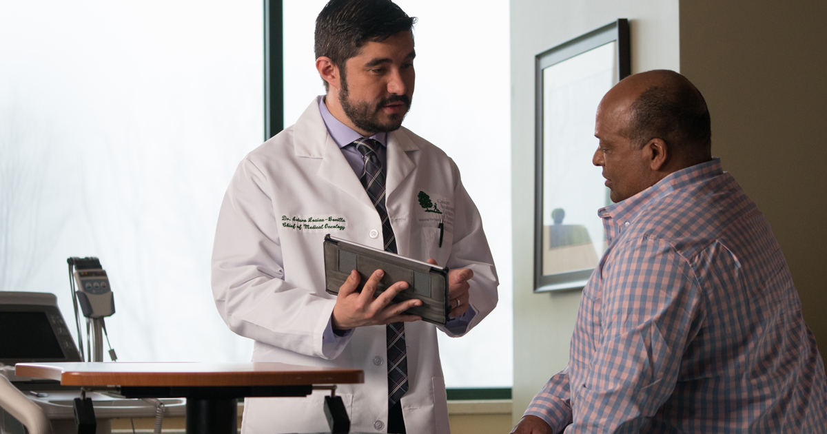 A male physician discussing paperwork with a male physician